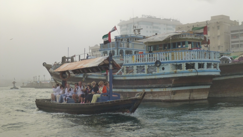 Abras, Holzboote, dienen als Taxi über den Dubai Creek. Im Hintergrund ein Transportschiff aus Holz