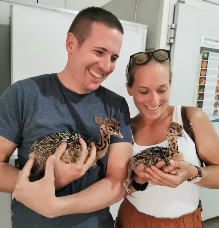 Jessi und ihr Freund halten zwei Straußenbabys in den Händen