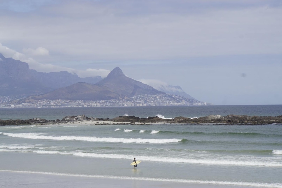 Ein Surfer am Blouberg Strand - im Hintergrund Kapstadt und der Berg Lions Head