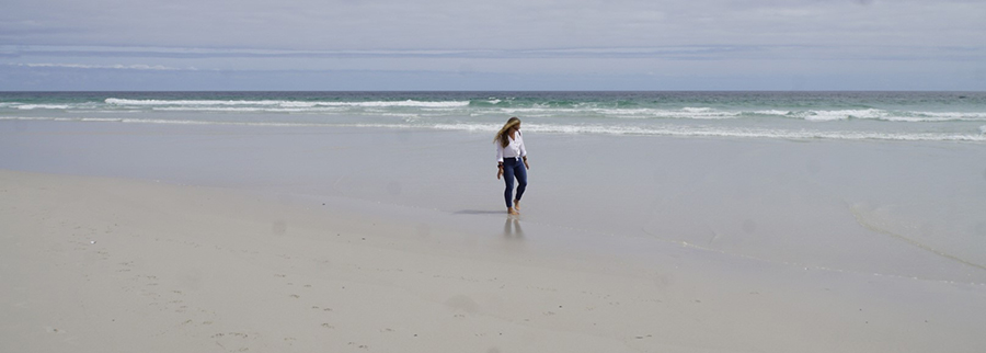 Jessi am breiten und menschenleeren von Noordhoek Beach, Südafrika